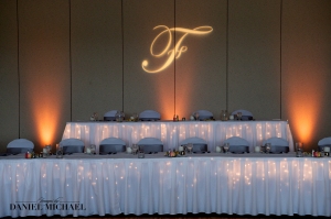 We love the look of this simple head table, with a monogram and uplights.